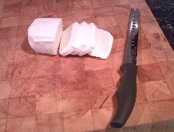 Slicing Halloumi cheese on a chopping board